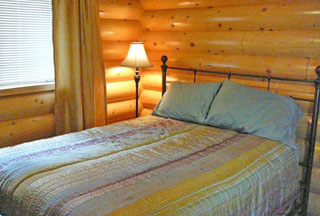 Queen pillow top bed with quality linen in log cabin room for cozy nights sleep
